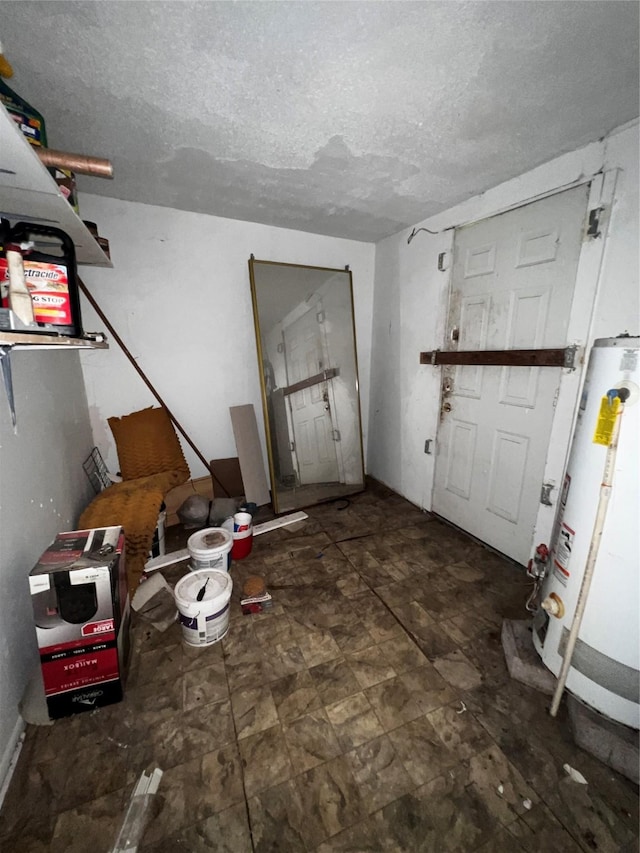 interior space featuring water heater and a textured ceiling