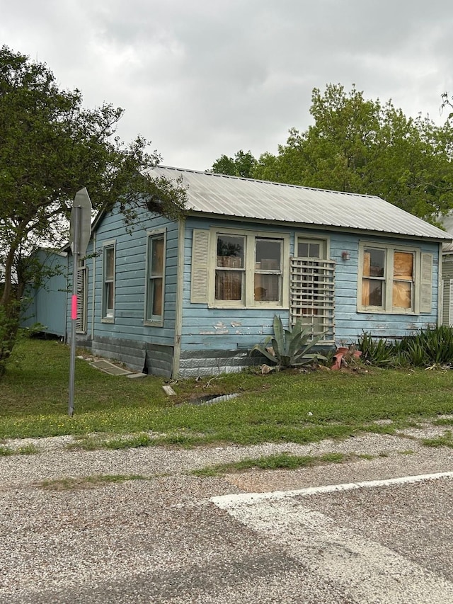 view of front of home featuring a front lawn and metal roof