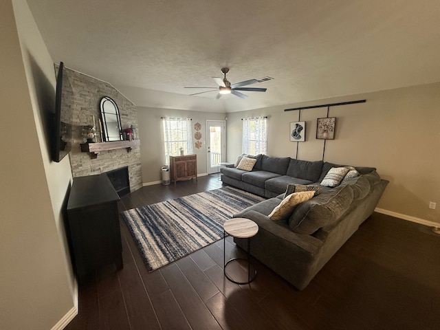 9319 Dalmore Ct, Houston, TX 77095 - living room with a stone fireplace, baseboards, ceiling fan, and dark wood-type flooring