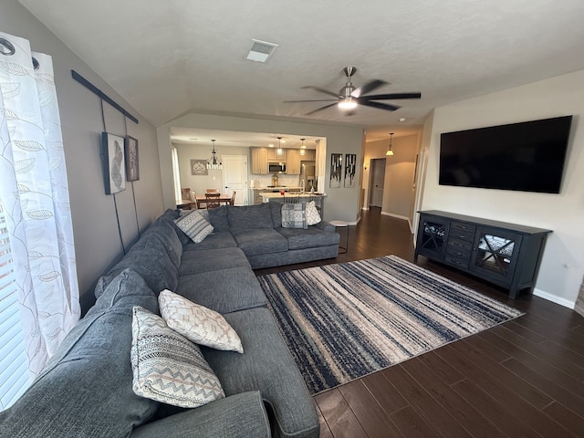 9319 Dalmore Ct, Houston, TX 77095 - living area featuring dark wood-style floors, vaulted ceiling, visible vents, and ceiling fan with notable chandelier