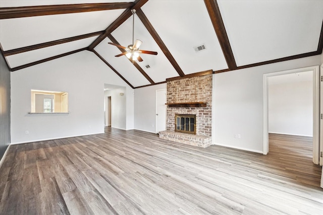 2825 Camelot Ln, Missouri City, TX 77459 - unfurnished living room featuring a ceiling fan, wood finished floors, a fireplace, beam ceiling, and visible vents