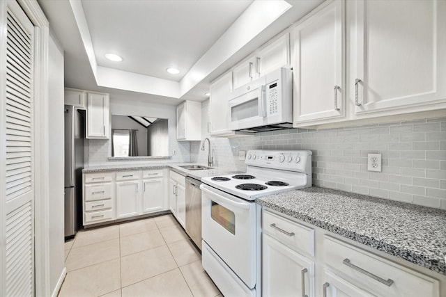 2825 Camelot Ln, Missouri City, TX 77459 - kitchen featuring light tile patterned flooring, appliances with stainless steel finishes, white cabinetry, and a sink