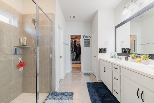 31511 Kailua Dr, Hockley, TX 77447 - full bath with a stall shower, a spacious closet, double vanity, tile patterned floors, and baseboards