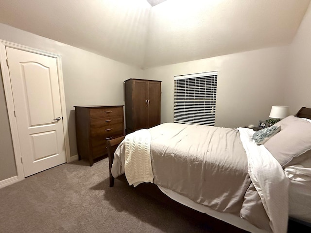 bedroom with light carpet, baseboards, and lofted ceiling