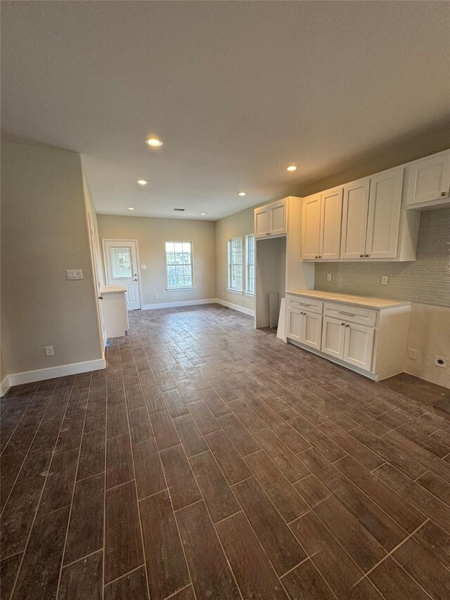 9830 Turnbow St, Houston, TX 77029 - kitchen with dark wood-type flooring, white cabinetry, baseboards, and recessed lighting