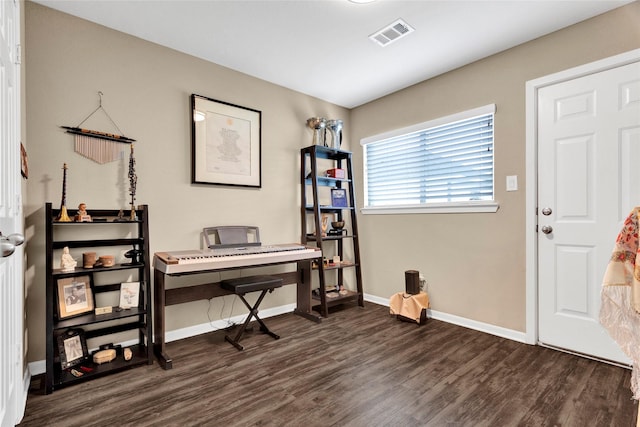 interior space with baseboards, visible vents, and dark wood-type flooring