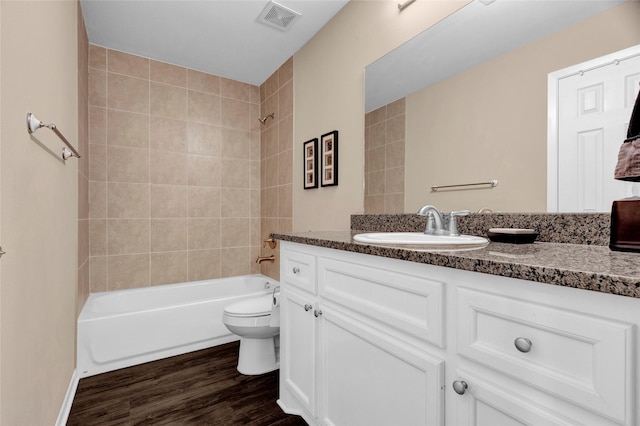 full bath featuring wood finished floors, shower / bathing tub combination, vanity, toilet, and visible vents
