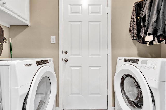 washroom featuring cabinet space and washing machine and clothes dryer