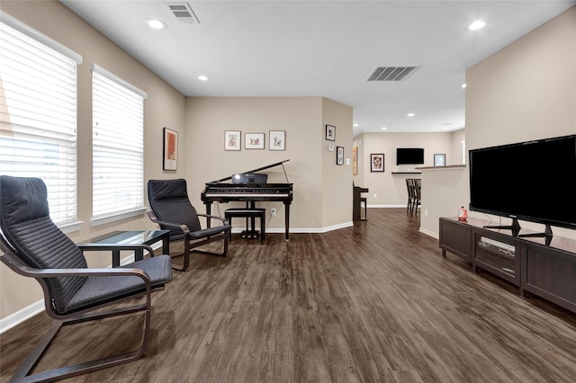 sitting room with baseboards, visible vents, and dark wood finished floors