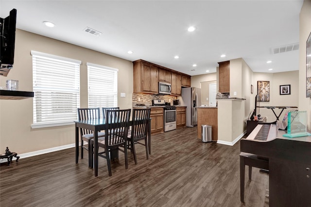 dining room featuring dark wood-type flooring, visible vents, baseboards, and recessed lighting