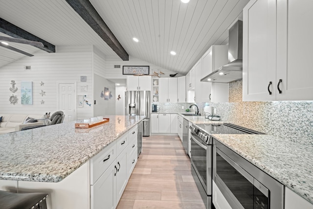 1407 John St, San Leon, TX 77539 - kitchen with wall chimney exhaust hood, stainless steel appliances, light wood-type flooring, light stone counters, and recessed lighting