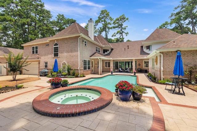 outdoor pool with an in ground hot tub and a patio