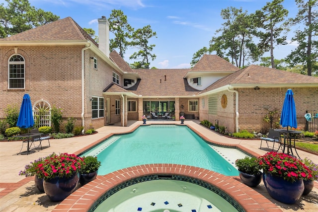outdoor pool with an in ground hot tub and a patio