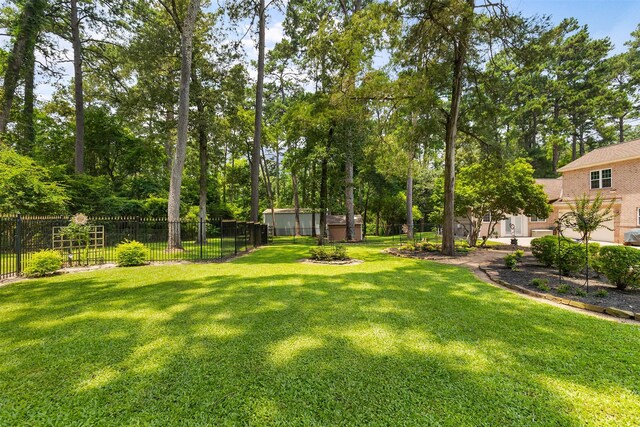 view of yard featuring a storage shed, an outdoor structure, and fence