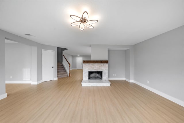 6718 Wild Pecan Trl, Houston, TX 77084 - unfurnished living room featuring baseboards, visible vents, stairs, and light wood-style flooring