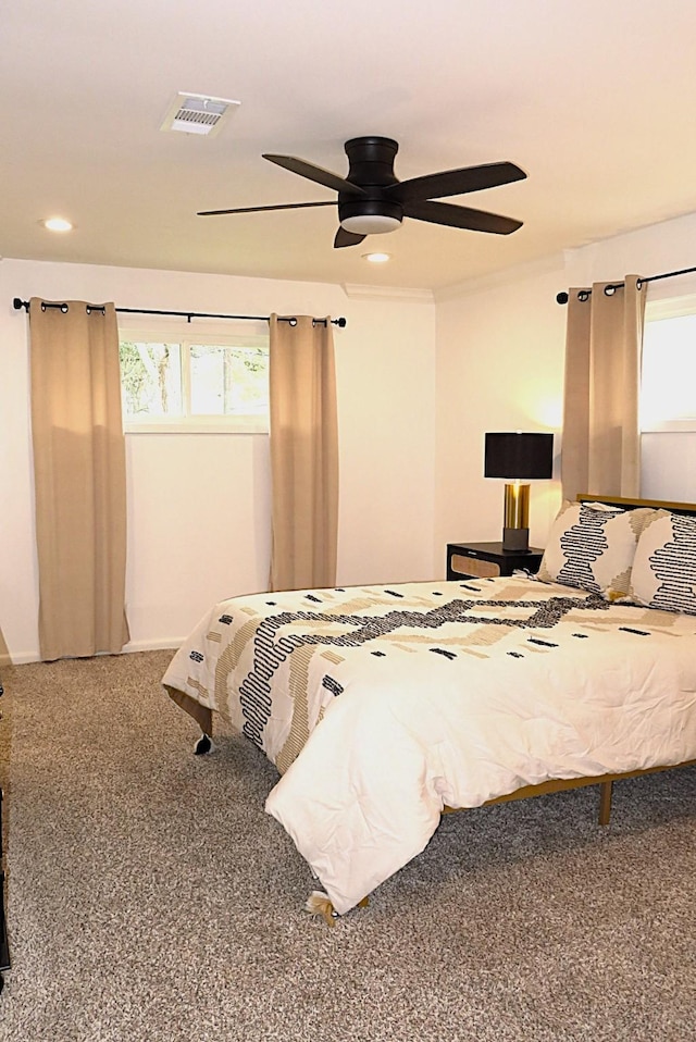 bedroom featuring ceiling fan, multiple windows, visible vents, and carpet