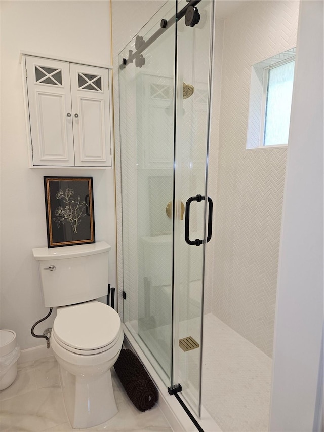 full bathroom with baseboards, marble finish floor, a shower stall, and toilet