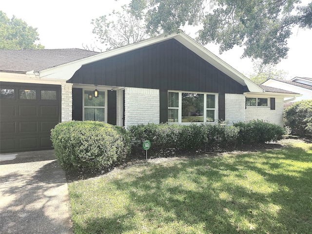 ranch-style house featuring a front lawn, brick siding, and a garage