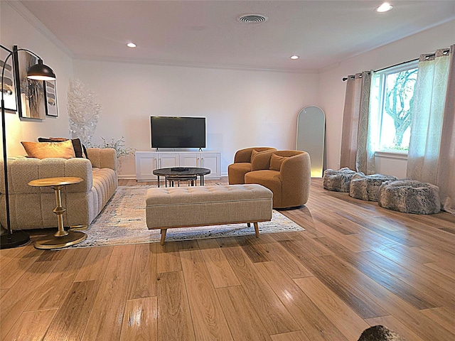living room featuring crown molding, light wood-style floors, visible vents, and recessed lighting