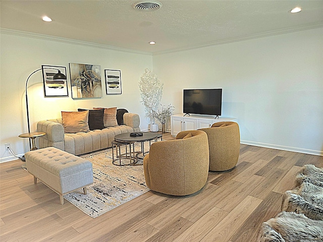 living room with visible vents, light wood-style floors, and crown molding