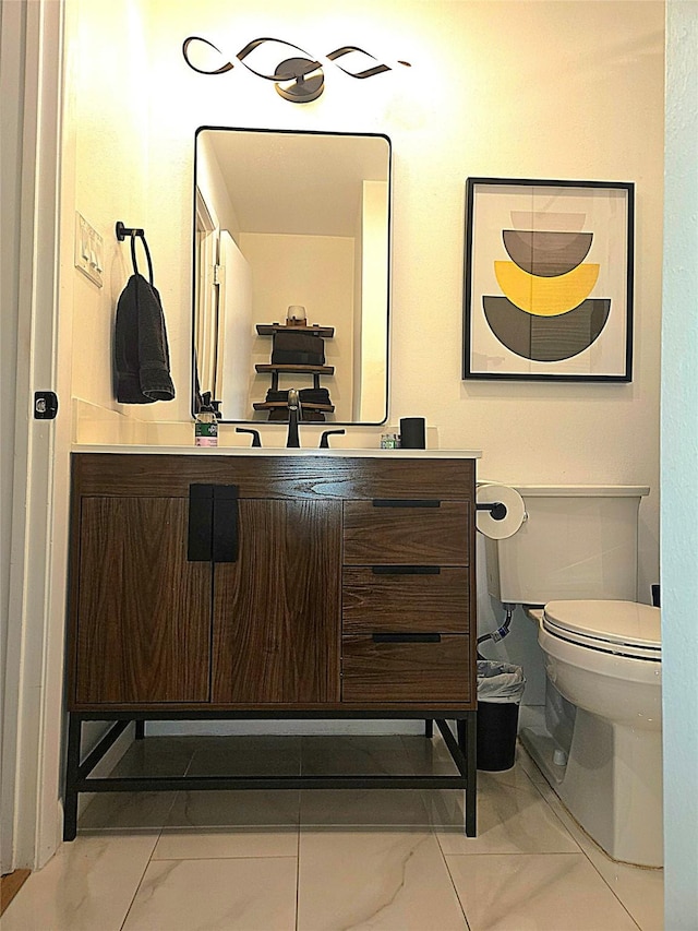 bathroom featuring marble finish floor, vanity, and toilet