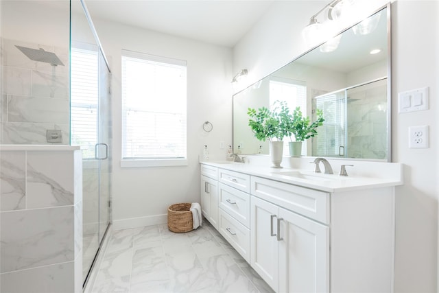 bathroom featuring marble finish floor, a sink, double vanity, and a stall shower