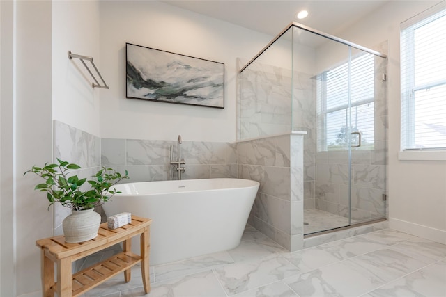 full bathroom featuring a stall shower, tile walls, marble finish floor, a freestanding bath, and recessed lighting