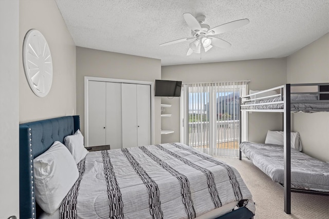 carpeted bedroom featuring access to outside, a ceiling fan, a closet, and a textured ceiling