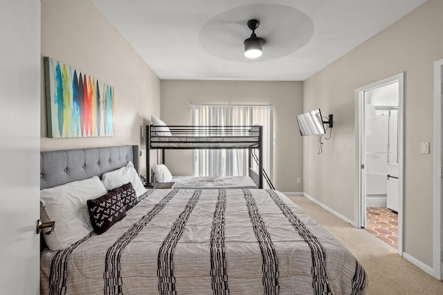 bedroom featuring baseboards, a ceiling fan, ensuite bathroom, and carpet