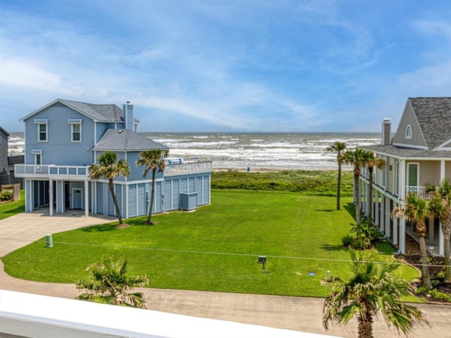 view of yard featuring driveway, an attached garage, a balcony, a water view, and central AC