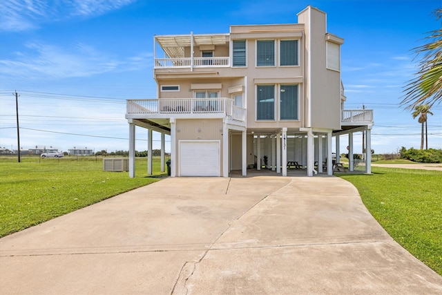 coastal inspired home featuring driveway, a front yard, a balcony, a carport, and a garage