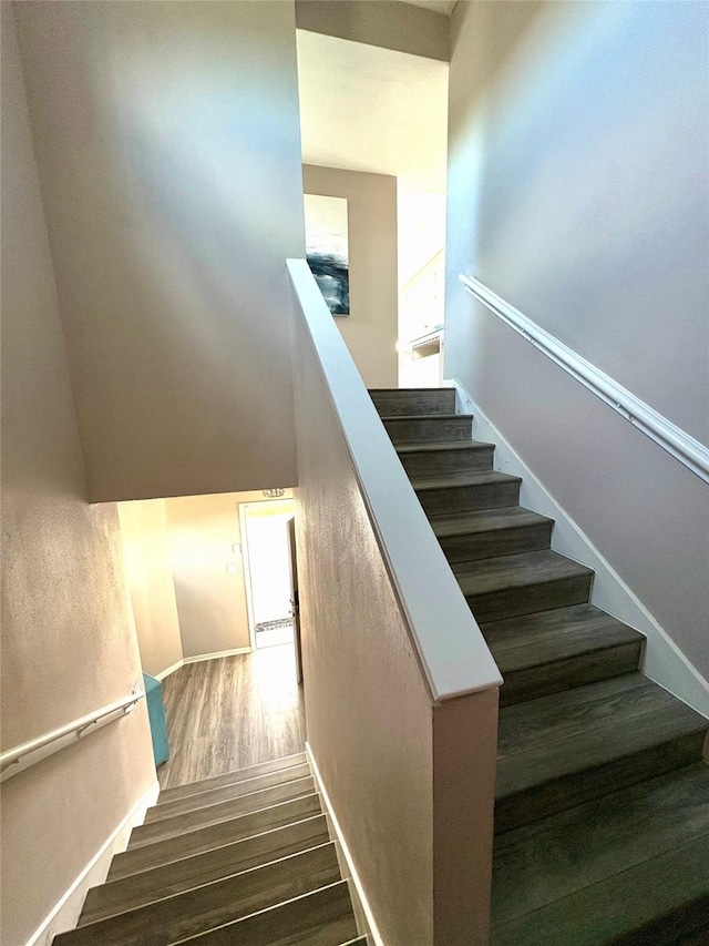 stairway with baseboards and wood finished floors