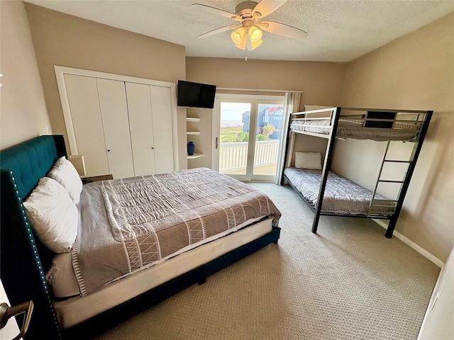carpeted bedroom featuring a closet, a textured ceiling, baseboards, a ceiling fan, and access to exterior