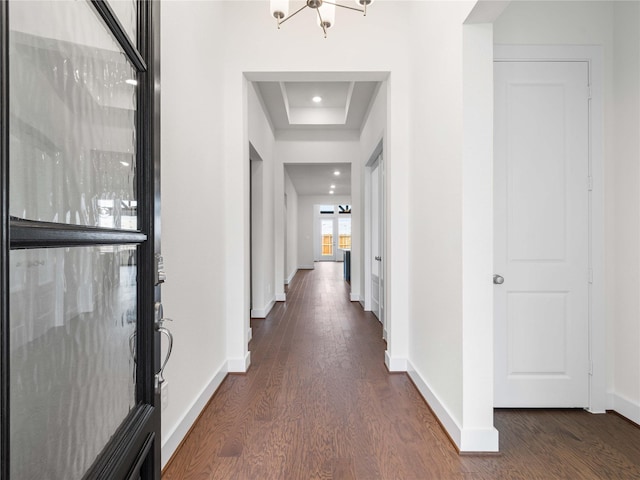 7517 Hawk Crest Dr, Fulshear, TX 77441 - hallway featuring dark wood-style flooring, a tray ceiling, and a chandelier