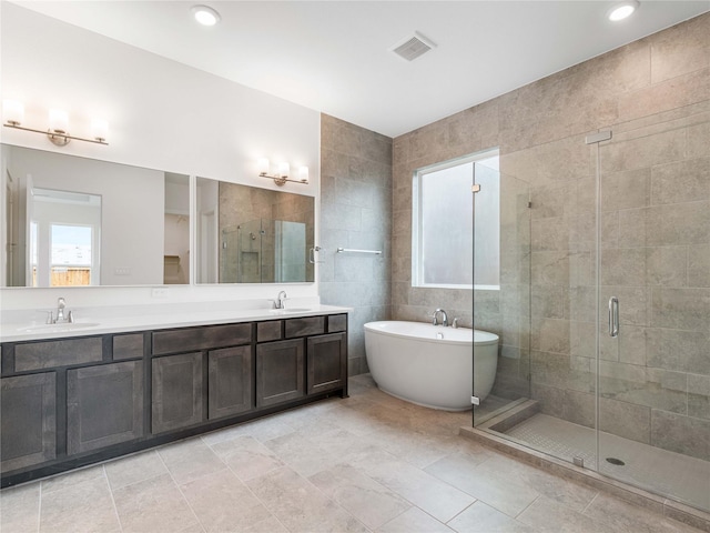 7517 Hawk Crest Dr, Fulshear, TX 77441 - bathroom with a stall shower, double vanity, a soaking tub, tile walls, and tile patterned floors