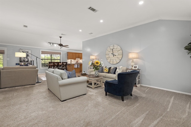 living area featuring a ceiling fan, baseboards, light colored carpet, visible vents, and ornamental molding