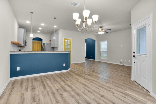 165 Camelot Place Ct, Conroe, TX 77304 - kitchen featuring stainless steel appliances, arched walkways, light wood finished floors, a chandelier, and baseboards