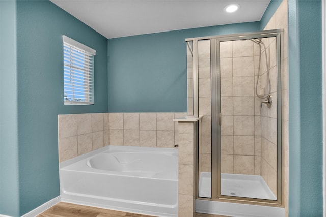165 Camelot Place Ct, Conroe, TX 77304 - bathroom featuring a stall shower, a bath, wood finished floors, and baseboards