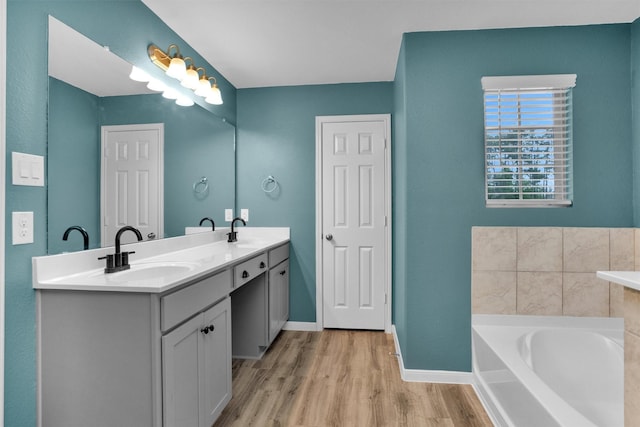 165 Camelot Place Ct, Conroe, TX 77304 - full bathroom with double vanity, wood finished floors, a bath, and baseboards