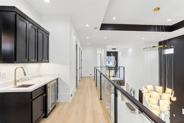 3902 Charleston St, Houston, TX 77021 - hall with wine cooler, light wood-style floors, an upstairs landing, and recessed lighting