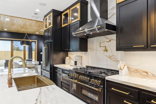 3902 Charleston St, Houston, TX 77021 - kitchen featuring wall chimney exhaust hood, high end appliances, glass insert cabinets, recessed lighting, and light stone countertops