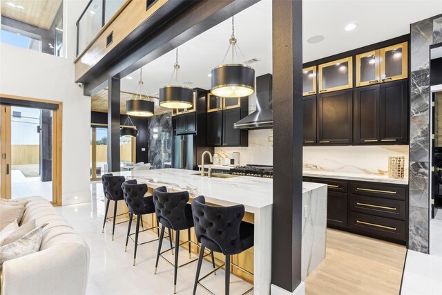 3902 Charleston St, Houston, TX 77021 - kitchen with wall chimney exhaust hood, open floor plan, a kitchen bar, light stone countertops, and backsplash