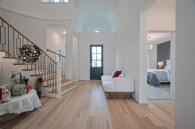 2611 Oakland Park Dr, Conroe, TX 77385 - foyer with a towering ceiling, light wood-type flooring, stairs, and a chandelier