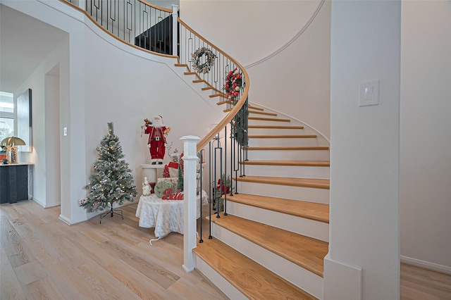 2611 Oakland Park Dr, Conroe, TX 77385 - staircase with wood finished floors, a towering ceiling, and baseboards