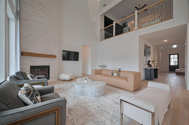 2611 Oakland Park Dr, Conroe, TX 77385 - living room with a stone fireplace, a high ceiling, and hardwood / wood-style flooring