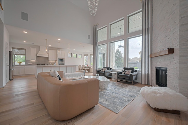 2611 Oakland Park Dr, Conroe, TX 77385 - living area featuring a towering ceiling, plenty of natural light, light wood finished floors, and a fireplace