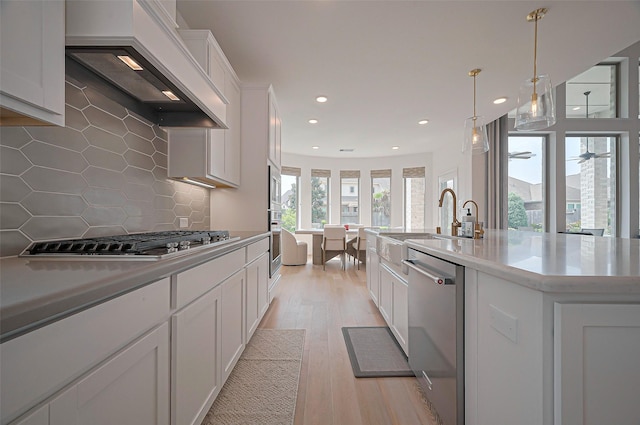 2611 Oakland Park Dr, Conroe, TX 77385 - kitchen featuring premium range hood, stainless steel appliances, white cabinetry, recessed lighting, and light countertops