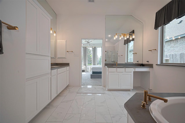 2611 Oakland Park Dr, Conroe, TX 77385 - full bathroom featuring two vanities, marble finish flooring, connected bathroom, a bathtub, and a shower with shower door