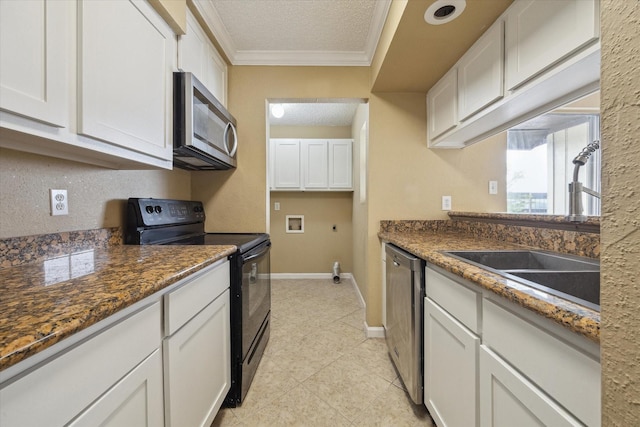 kitchen featuring crown molding, a textured ceiling, stainless steel appliances, baseboards, and white cabinets