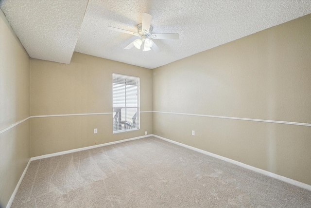 spare room with a ceiling fan, carpet, baseboards, and a textured ceiling